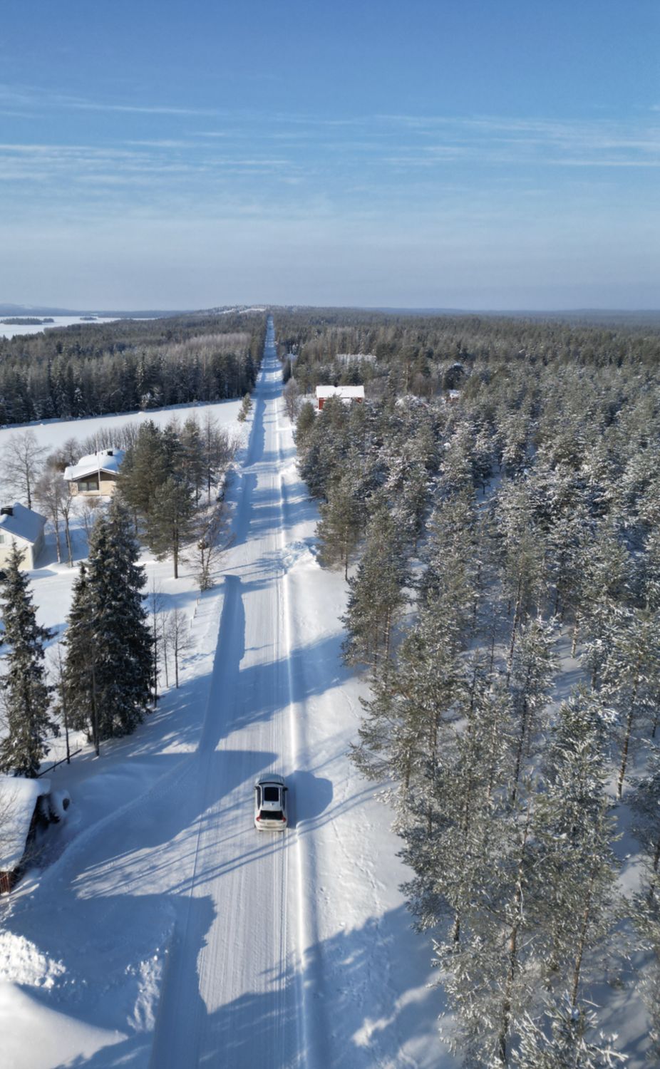 Авто на прямій засніженій дорозі, вид з дрона